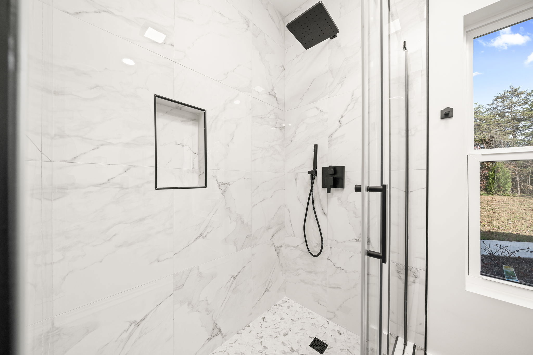 Tiled walk-in shower with glass enclosure